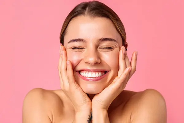 Młoda kobieta o promiennej skórze dzięki pielęgnacji bogatej w ceramidy